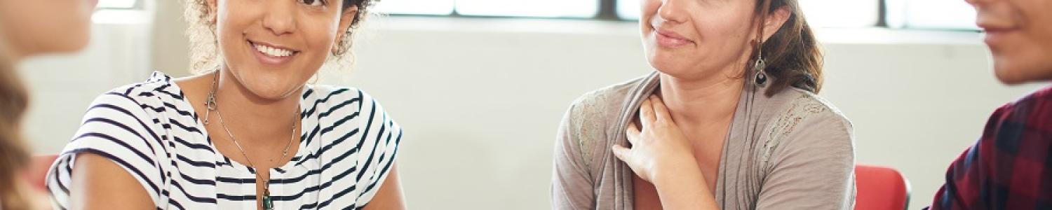Educators with pleased expressions talking together at a table