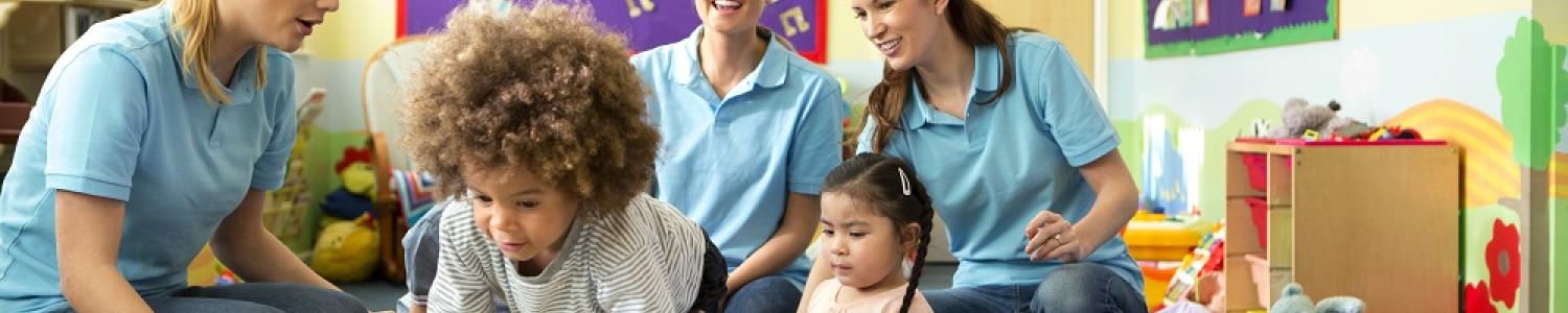 Educators and children playing on soft equipment
