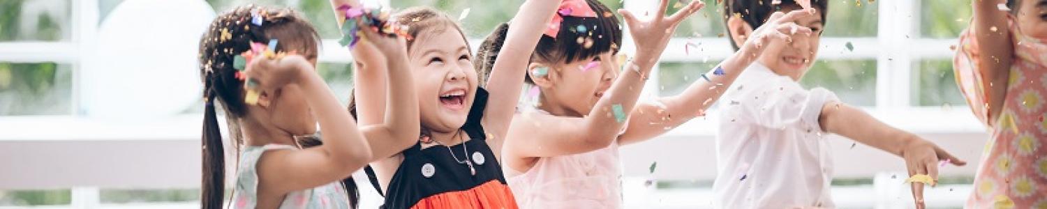 Happy children celebrating with arms held high