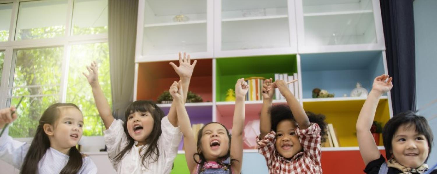 Young children with arms up in the air in celebration