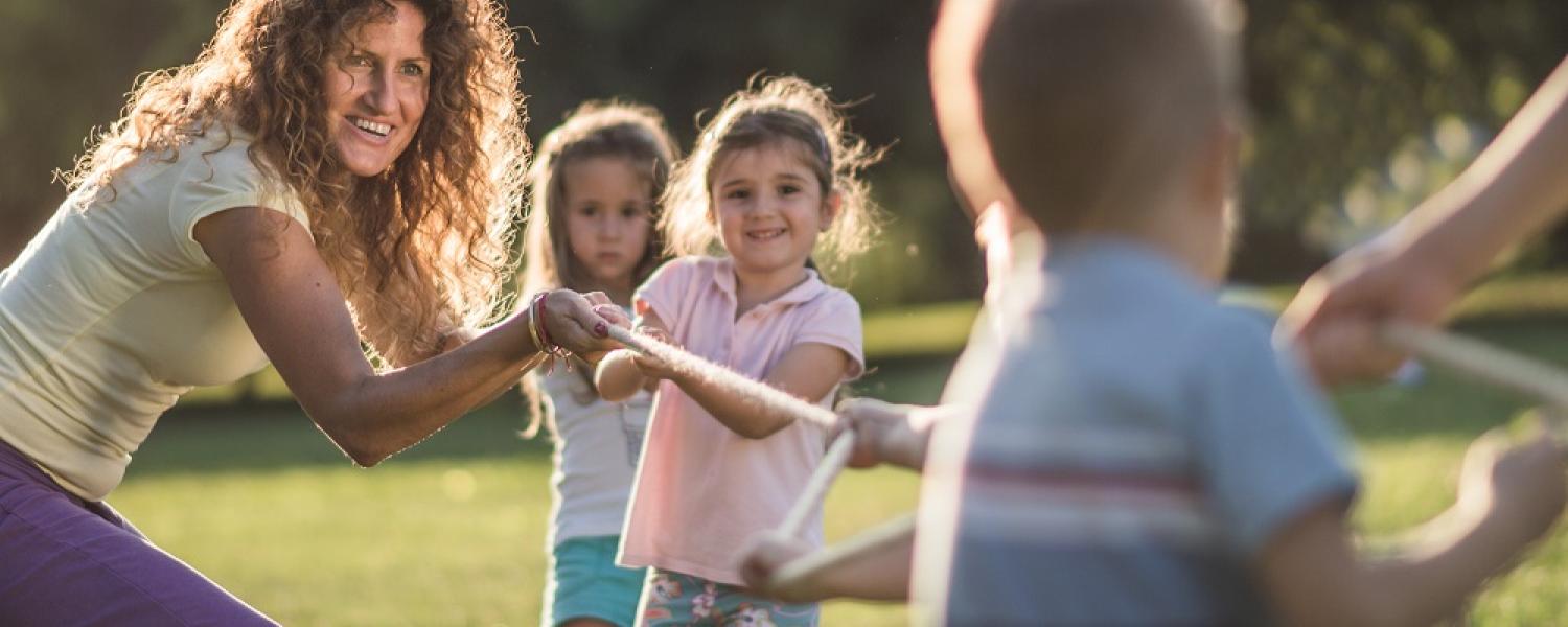 Educator playing a tug of rope game with children