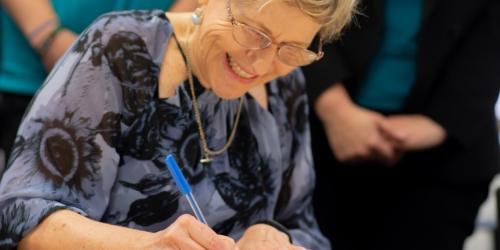 Julie Price Executive Director, Community Child Care Association, signing documents