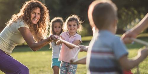 Educator playing a tug of rope game with children